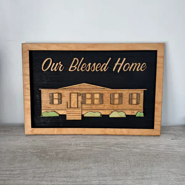 Wood-framed chalkboard showing the phrase 'Our Blessed Home' with a wooden house illustration beneath it.